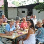 Die Gäste geniessen den Sonnenschein und die leckeren Torten im Kirchgarten