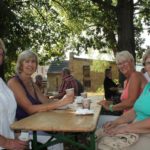 Die Gäste geniessen den Sonnenschein und die leckeren Torten im Kirchgarten