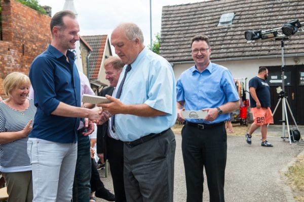 Bürgermeister Ulli Leipnitz übergibt den Spendenstein an Hagen Bulwan
